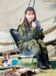 A woman sitting in a chair holding a cup of coffee.