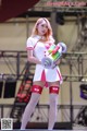 A woman in a white and red outfit holding a water gun.