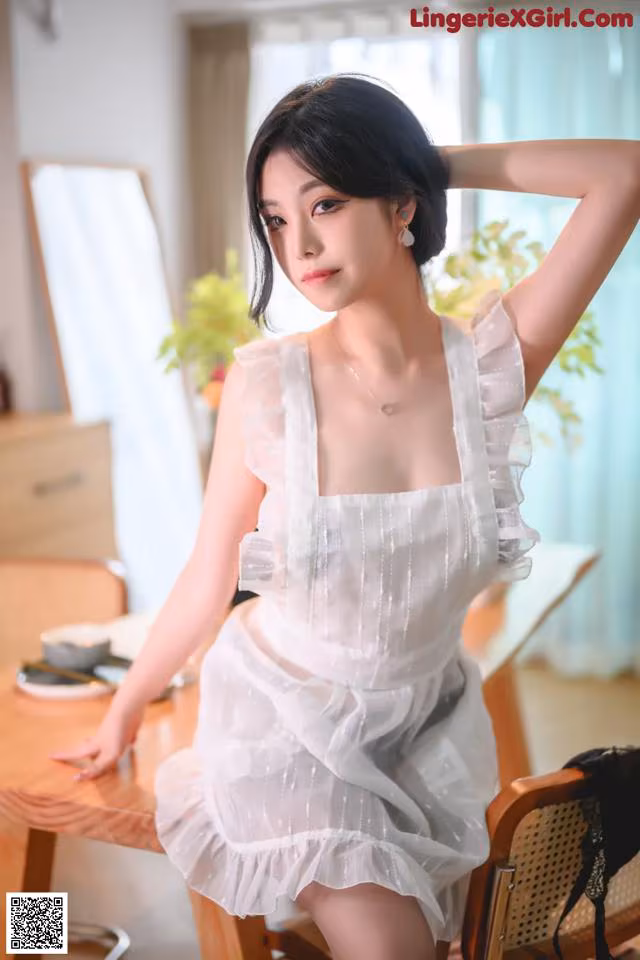 a woman in a white dress sitting at a table