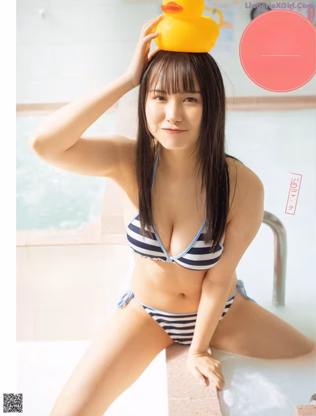 A woman in a bikini with a rubber duck on her head.