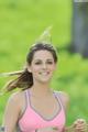 A woman in a pink sports bra smiling at the camera.