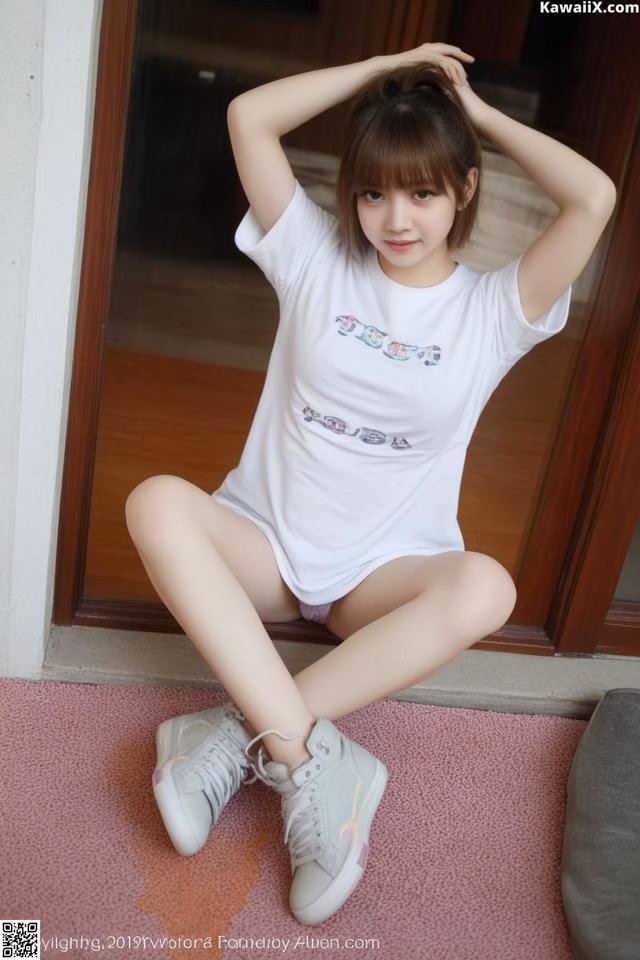 A woman in a white shirt and white sneakers posing for a picture.