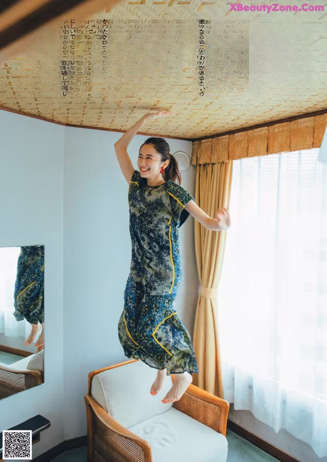 A woman jumping in the air in a room.