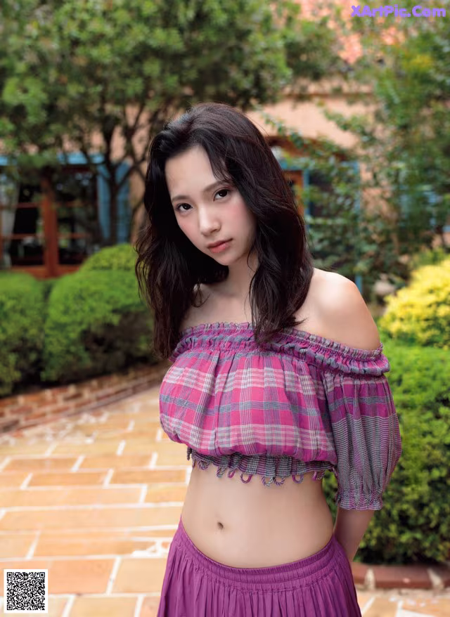 A woman in a purple skirt is posing for a magazine.