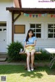 A woman sitting on a bench in front of a house.