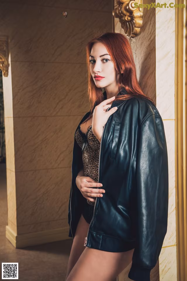 A woman in a black leather jacket posing for a picture.