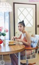 A woman sitting at a table with a plate of pancakes.