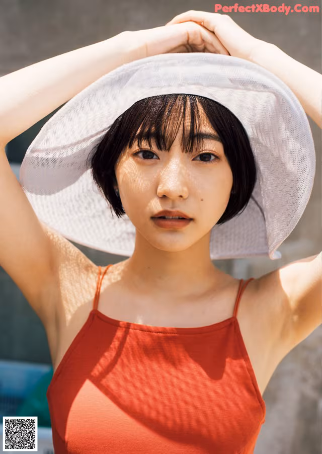 A woman in a red dress and a white hat.