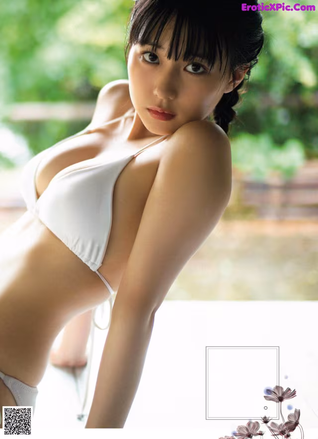 A woman in a white bikini posing for a magazine.