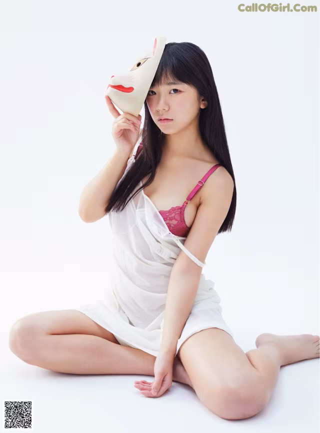 A woman sitting on the floor holding a stuffed animal.