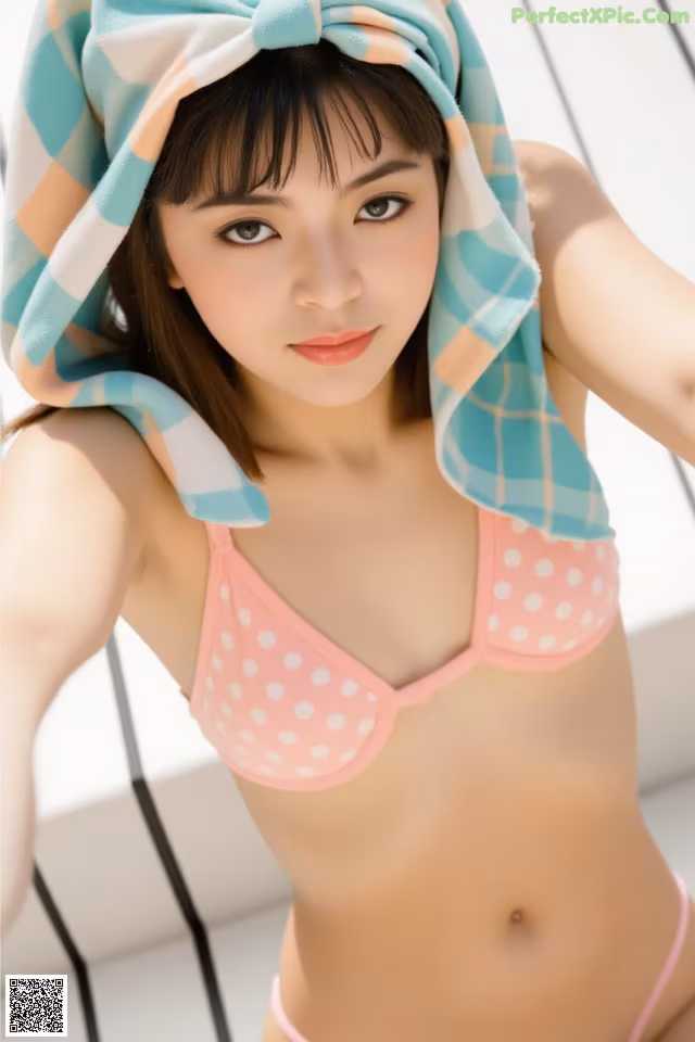 A woman in a pink bikini with a towel wrapped around her head.