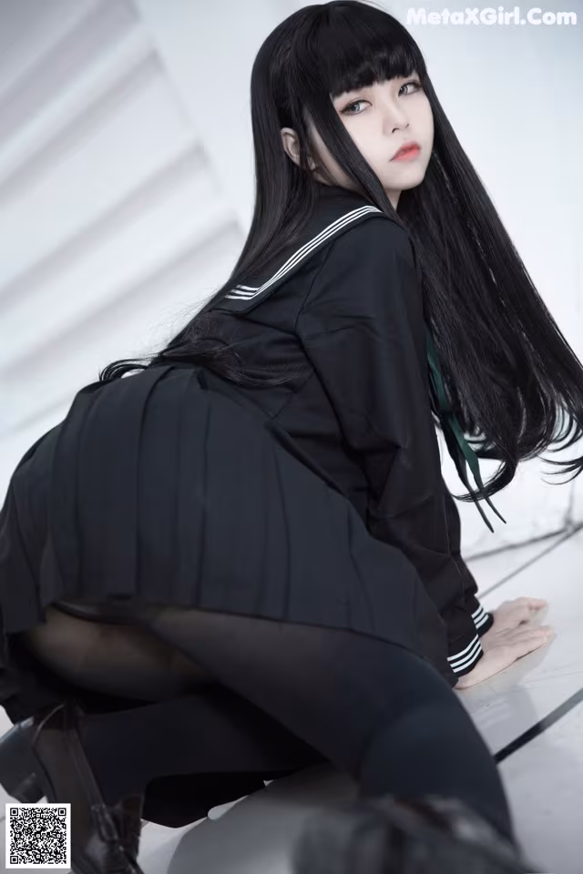 A woman in a school uniform crouching on the floor.