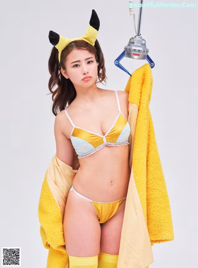 A woman in a yellow and white lingerie holding a yellow towel.