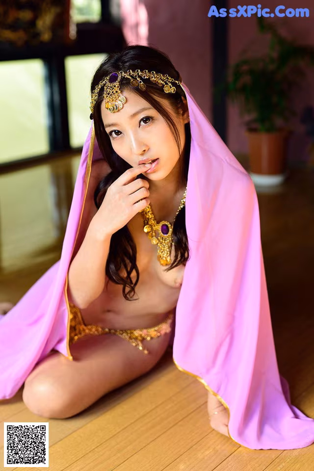 A woman in a pink dress sitting on the floor.