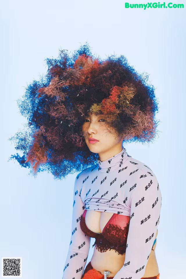 A woman with an afro is posing for a picture.