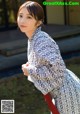 A woman in a black and white kimono is posing for a picture.